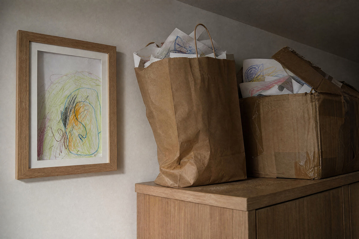 Bags and boxes of loose children's drawings next to one framed drawing