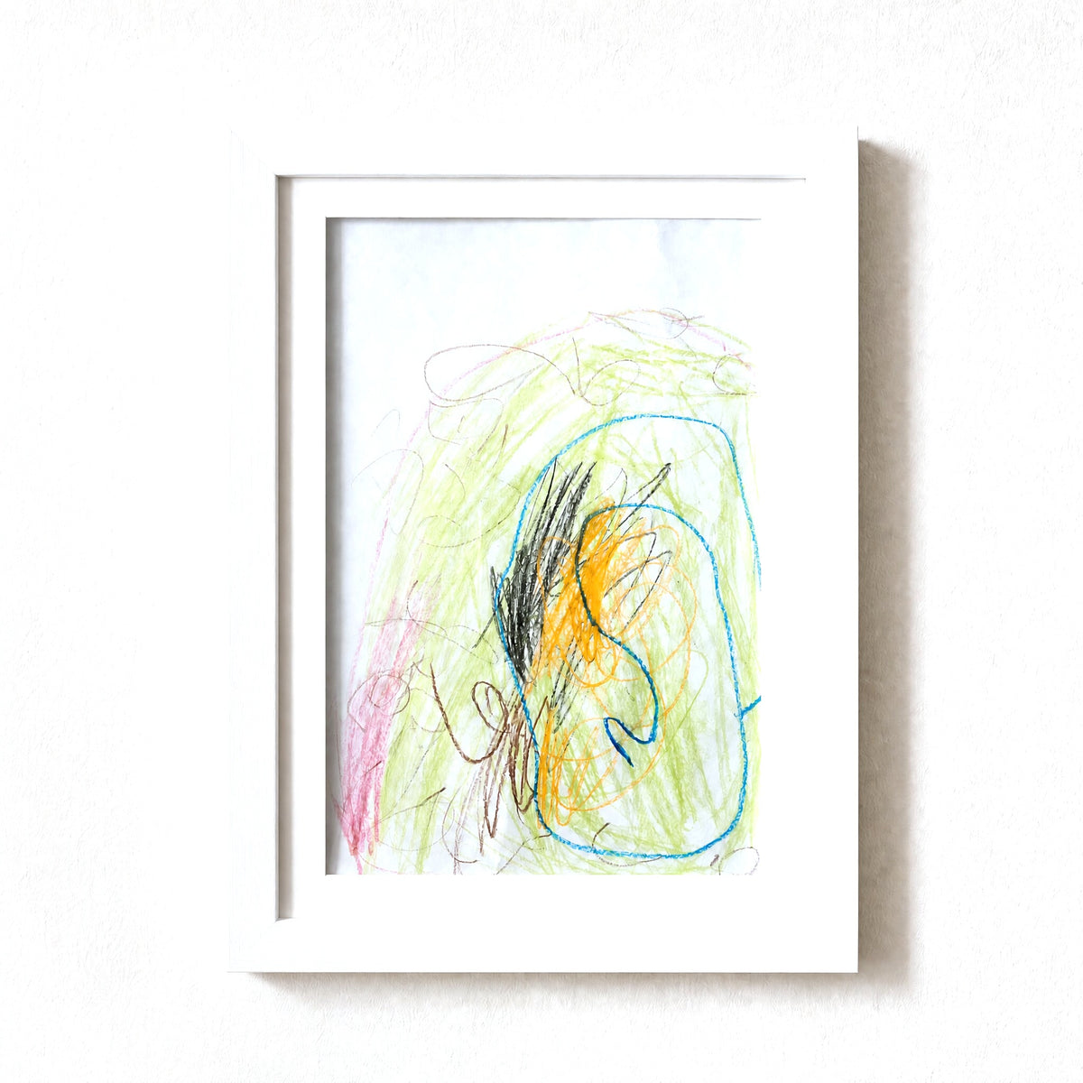 PeekDoodle art frame in white on a wall, holding a child's crayon drawing