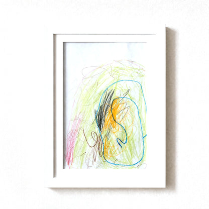 PeekDoodle art frame in white on a wall, holding a child's crayon drawing